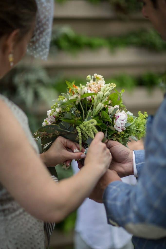 Tying the mini bouqets together Alisa Tongg Celebrant Family Vow Renewal at The Living Wall at Promise Ridge Jeremie Barlow Photography