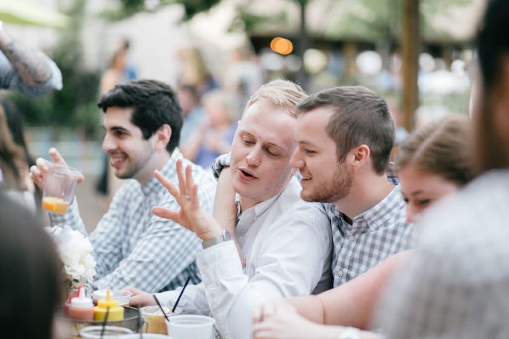 dustin looking at his ring with friends alisa tongg celebrant race street peir philadelphia wedding emily wren photography