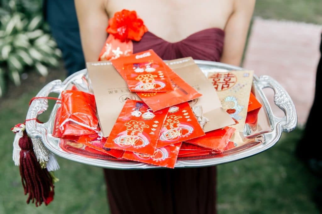 silver platter of lai si and hong bao red evnelopes after chinese wedding tea ceremony pomme at radnor alisa tongg celebrant emily wren photography 1