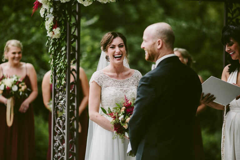 “Couple laughing during a personalized wedding ceremony led by celebrant Alisa Tongg.”