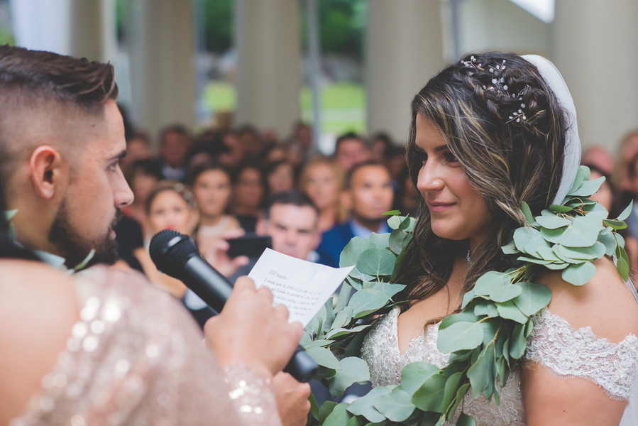 Groom reading personal vows to his bride as their wedding witnesses look on.”
