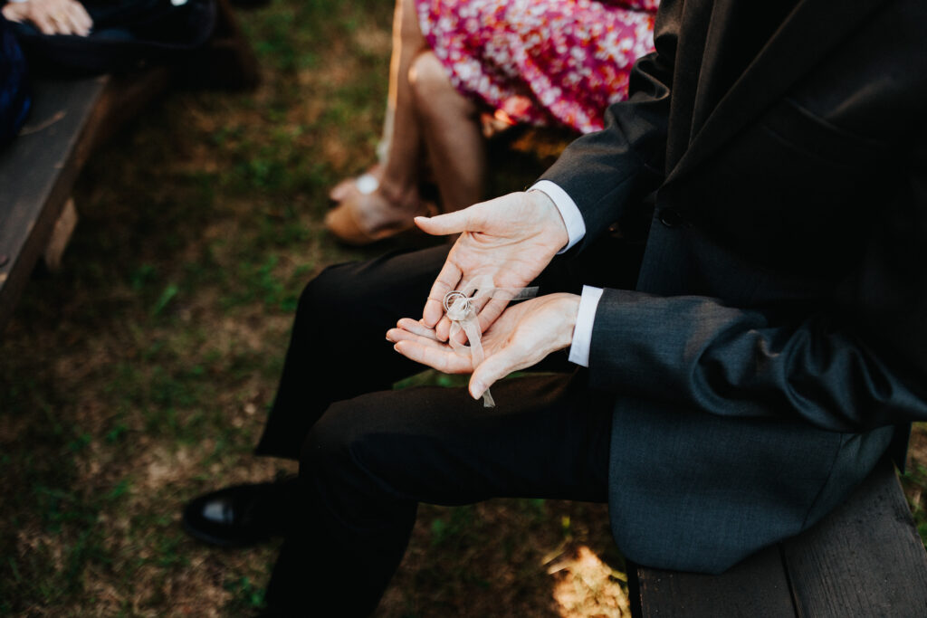 Wedding rings held by a loved one during a participatory ring blessing.